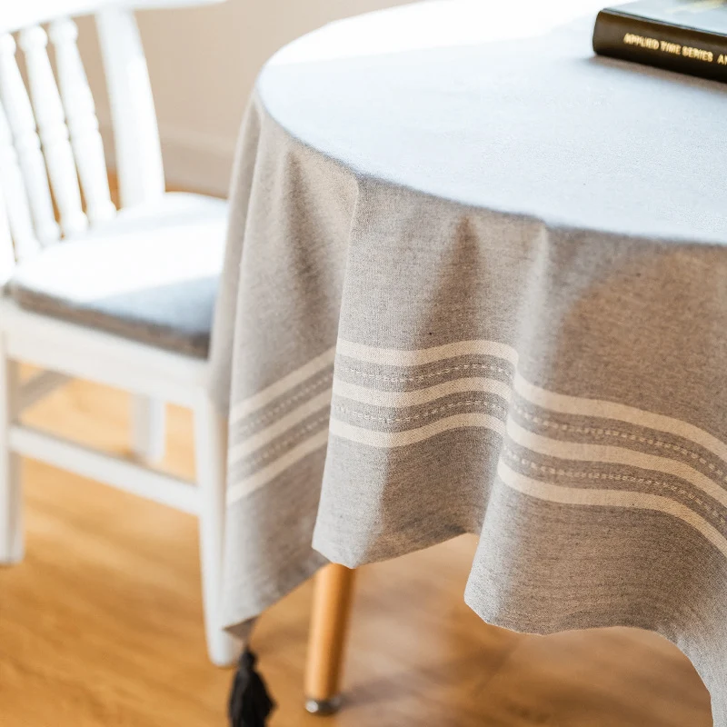 Rechteckige Tischdecke aus Baumwoll‑Leinen‑Mischung mit dezenter Streifenbordüre und dekorativen Quasten