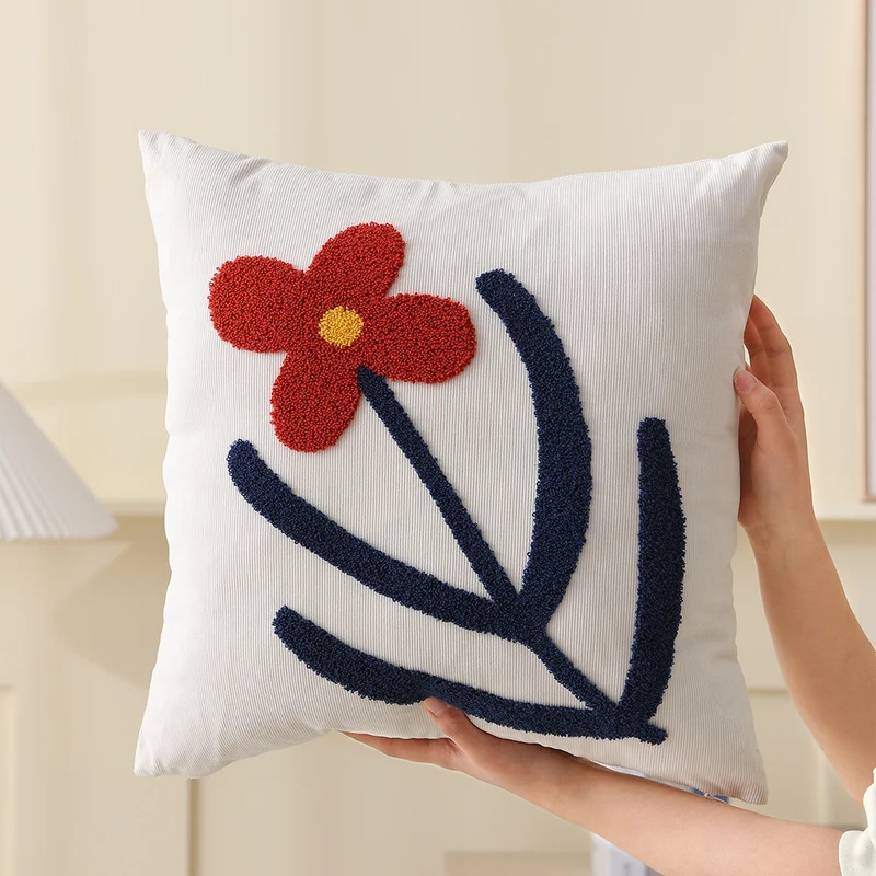 Quadratisches Dekokissen mit handgetuftetem Herzornament und kontrastierendem Rahmen