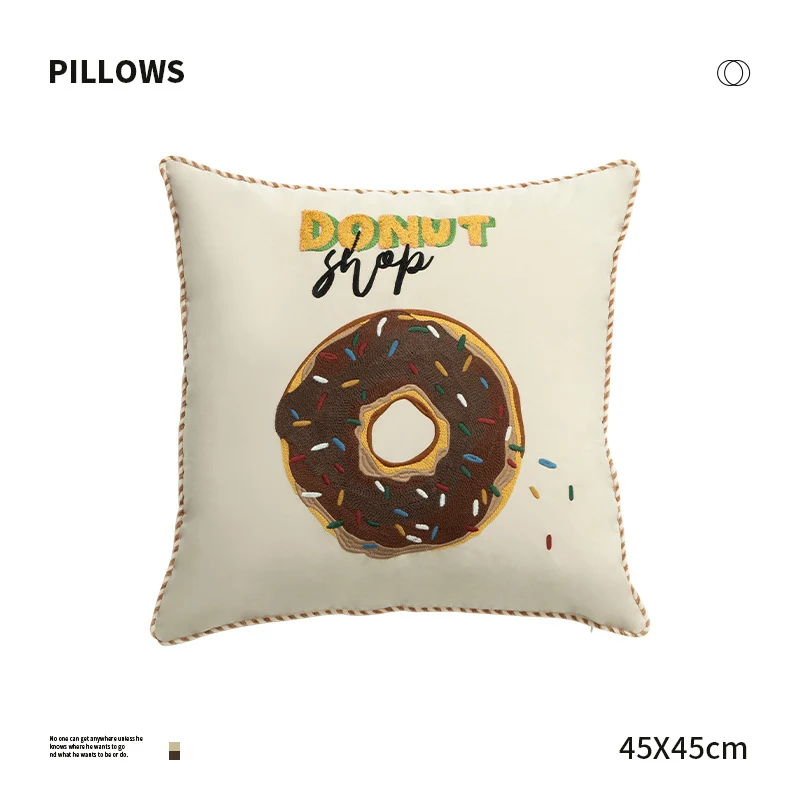 Quadratisches Dekokissen mit gesticktem Donut-Motiv und dekorativer Kederkante