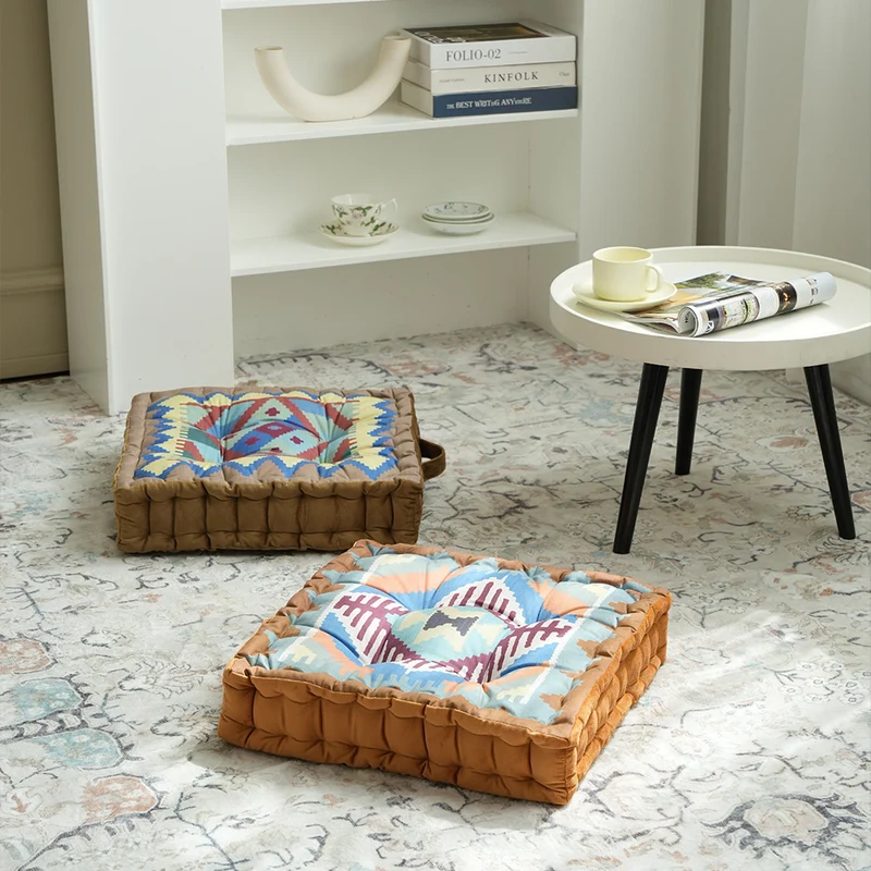 Quadratisches Sitzkissen mit kilim-inspiriertem Muster, gesteppter Polsterung und Traggriff