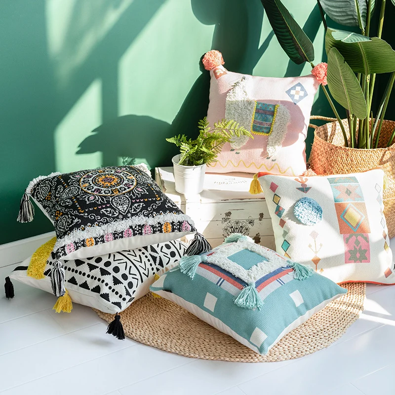 Quadratisches Boho-Dekokissen mit gehäkeltem Bommel und dekorativen Eckquasten