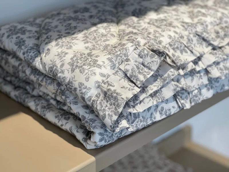 Leicht gesteppte Wohndecke im Vintage‑Blumenprint mit Rüschenrand