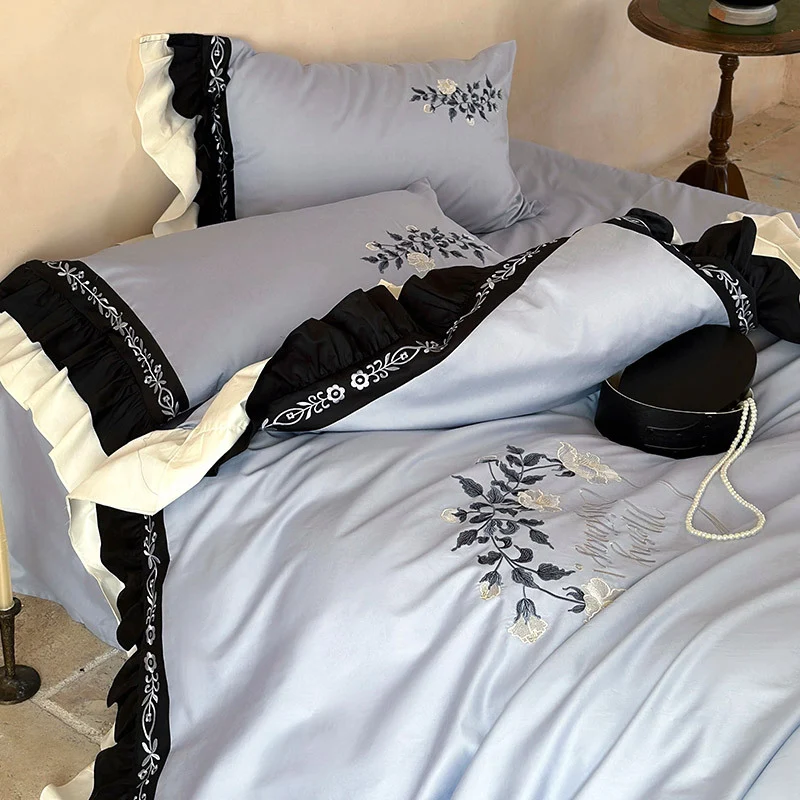 Elegante Bettwäsche-Garnitur aus Baumwollsatin mit Stickerei, kontrastierendem Volant und Rundkissen