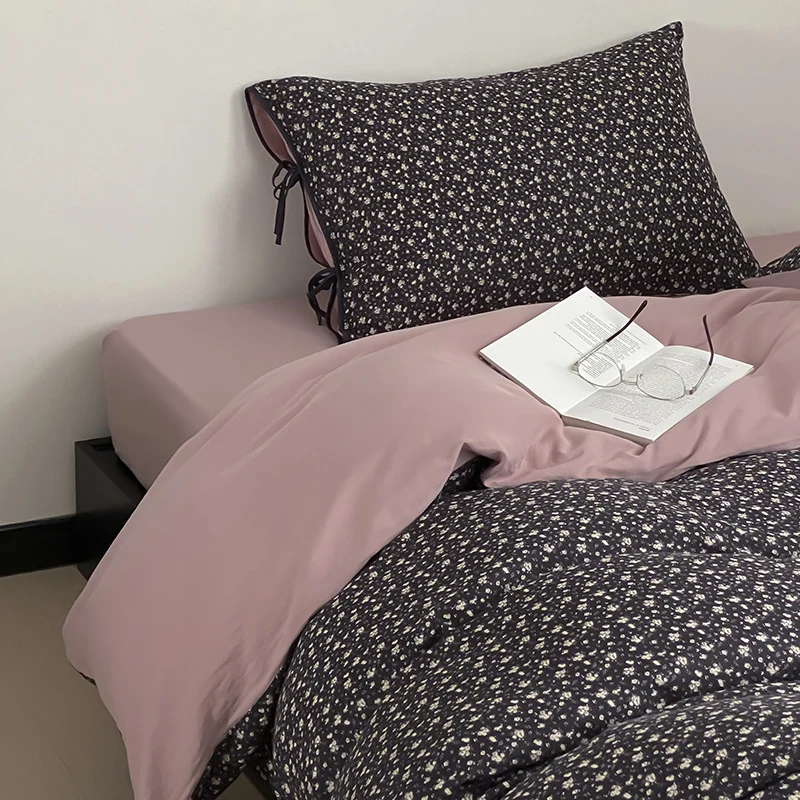 Wendbare Bettwäsche‑Garnitur aus Baumwollsatin mit feinem Blumenallover, kontrastierter Innenseite und dekorativen Schleifen