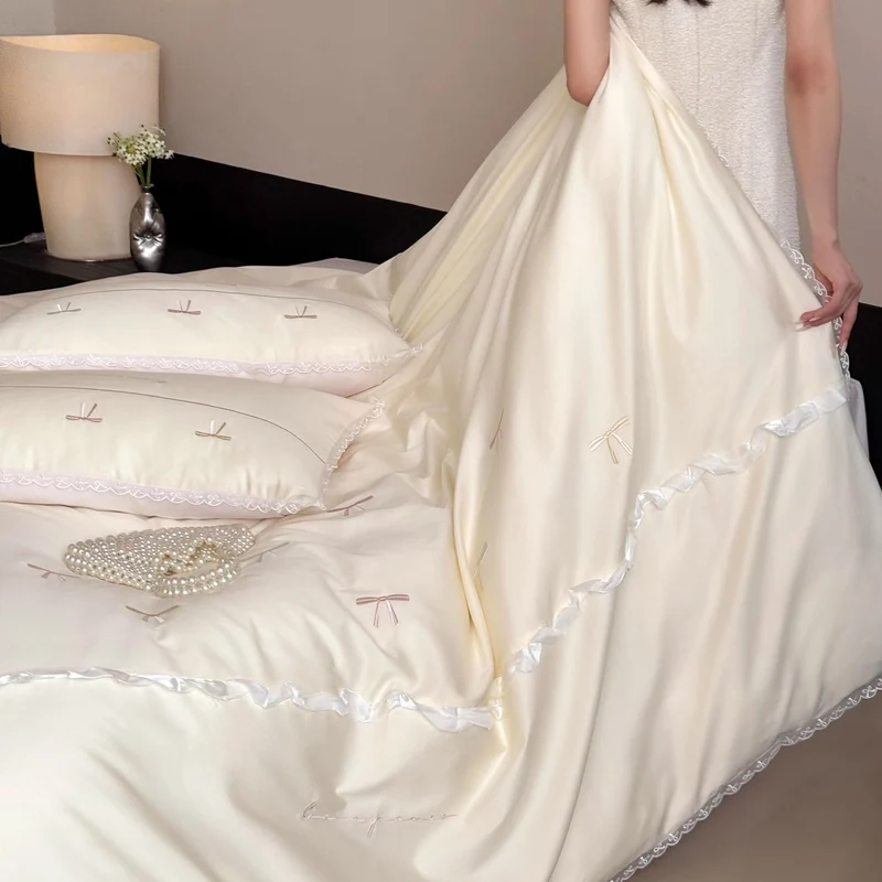 Elegante Bettwäschegarnitur aus seidig-feinem Satin mit bestickten Schleifen und Spitzenbordüre