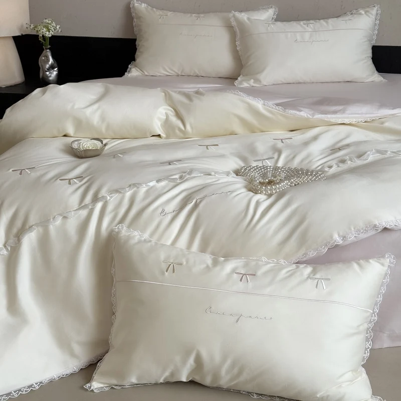 Elegante Bettwäschegarnitur aus seidig-feinem Satin mit bestickten Schleifen und Spitzenbordüre