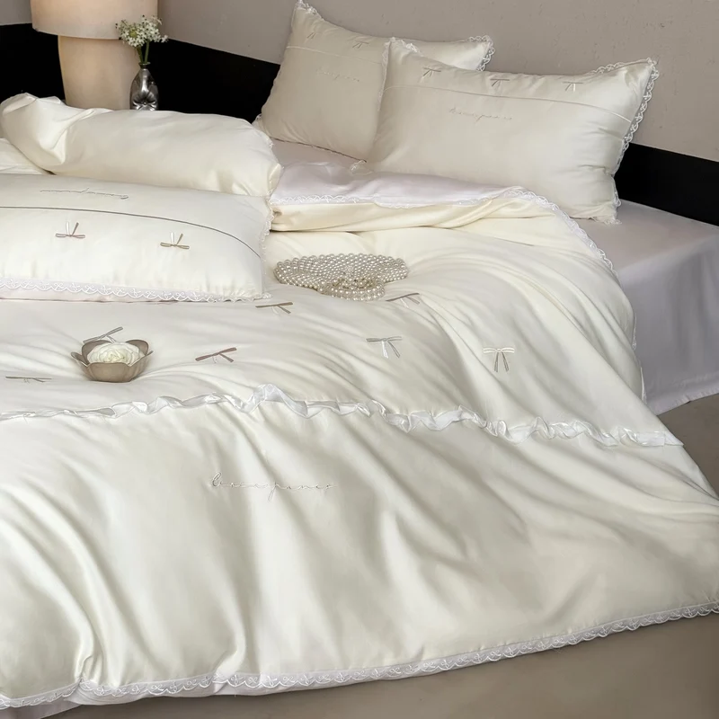 Elegante Bettwäschegarnitur aus seidig-feinem Satin mit bestickten Schleifen und Spitzenbordüre