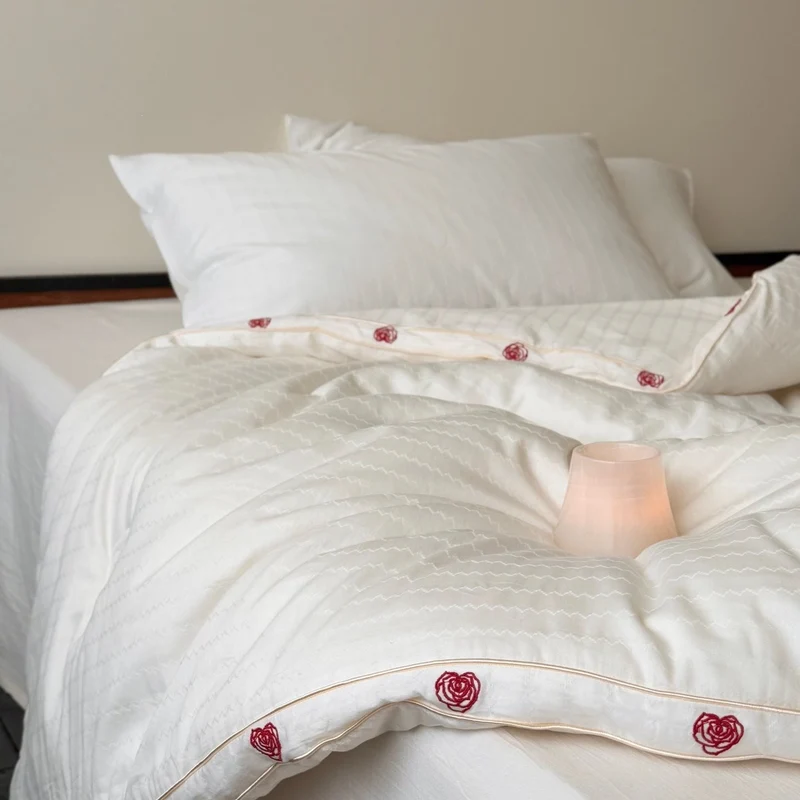 Steppbett aus Baumwollsatin mit gestickter Rosenborte