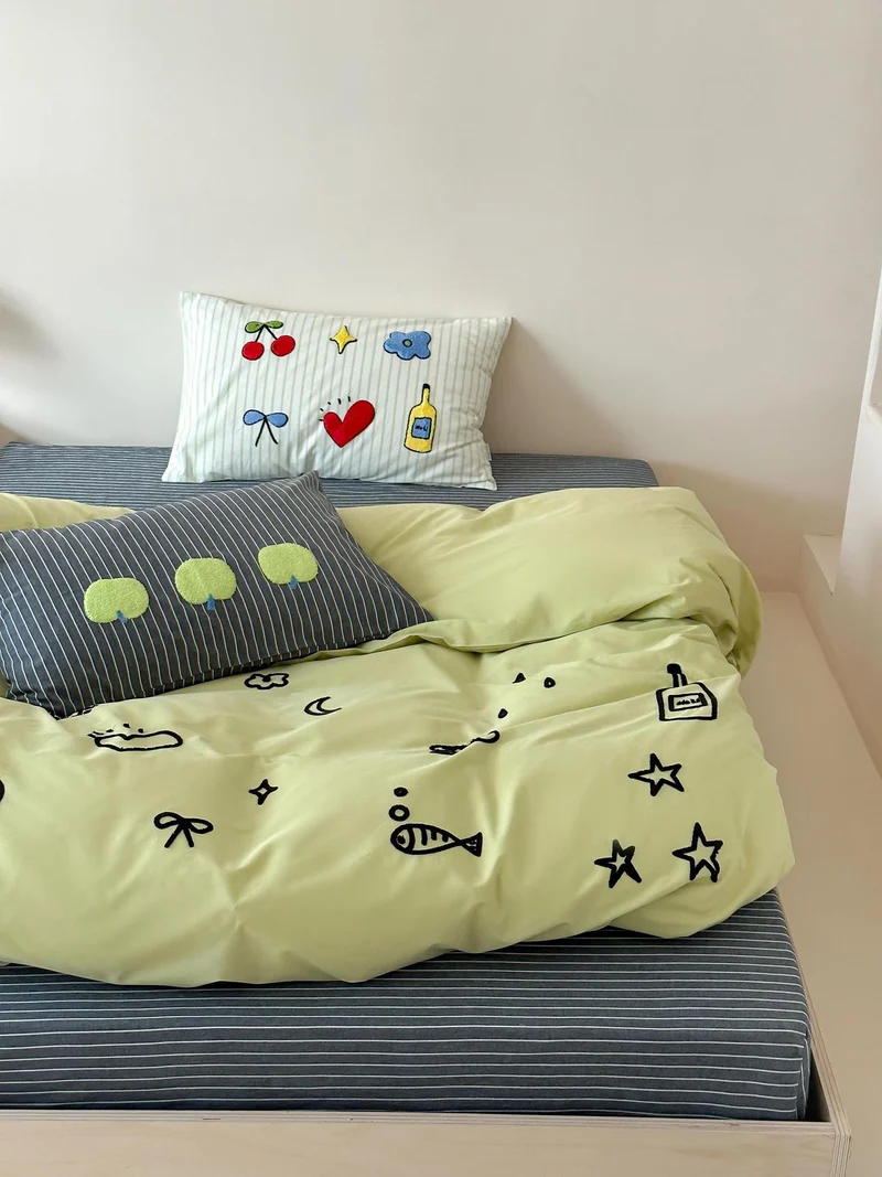 Verspieltes Baumwoll-Bettbezug-Set mit gestickten Motiven und weichem Spannbetttuch