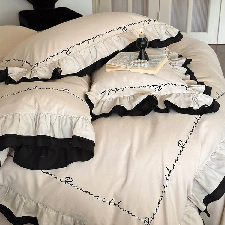 Luxuriöse Baumwoll-Satin-Bettwäschegarnitur mit Volant, kontrastierender Paspel und kalligrafischer Stickschrift