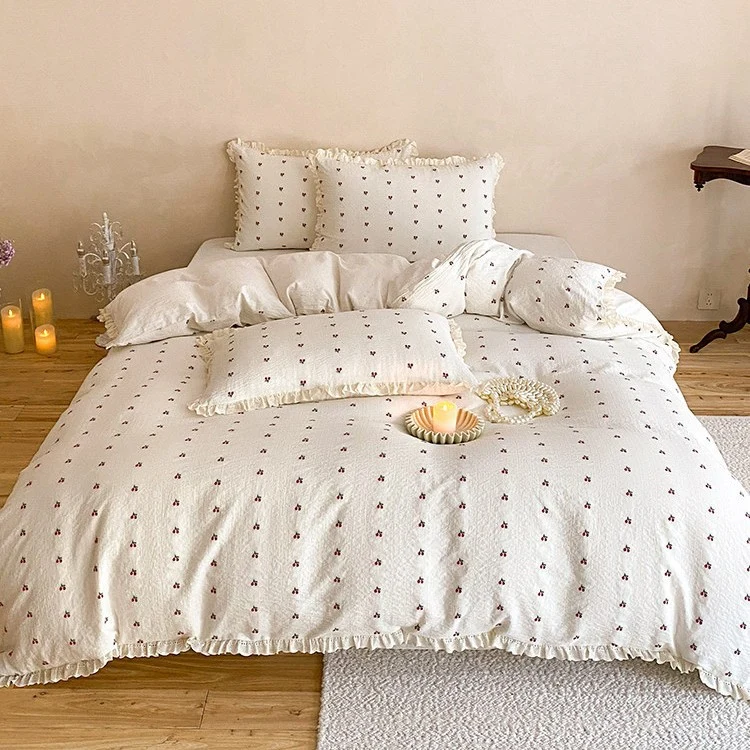 Gestepptes Bettwäscheset aus Baumwoll‑Musselin mit zartem Kirschenprint und Rüschenkante